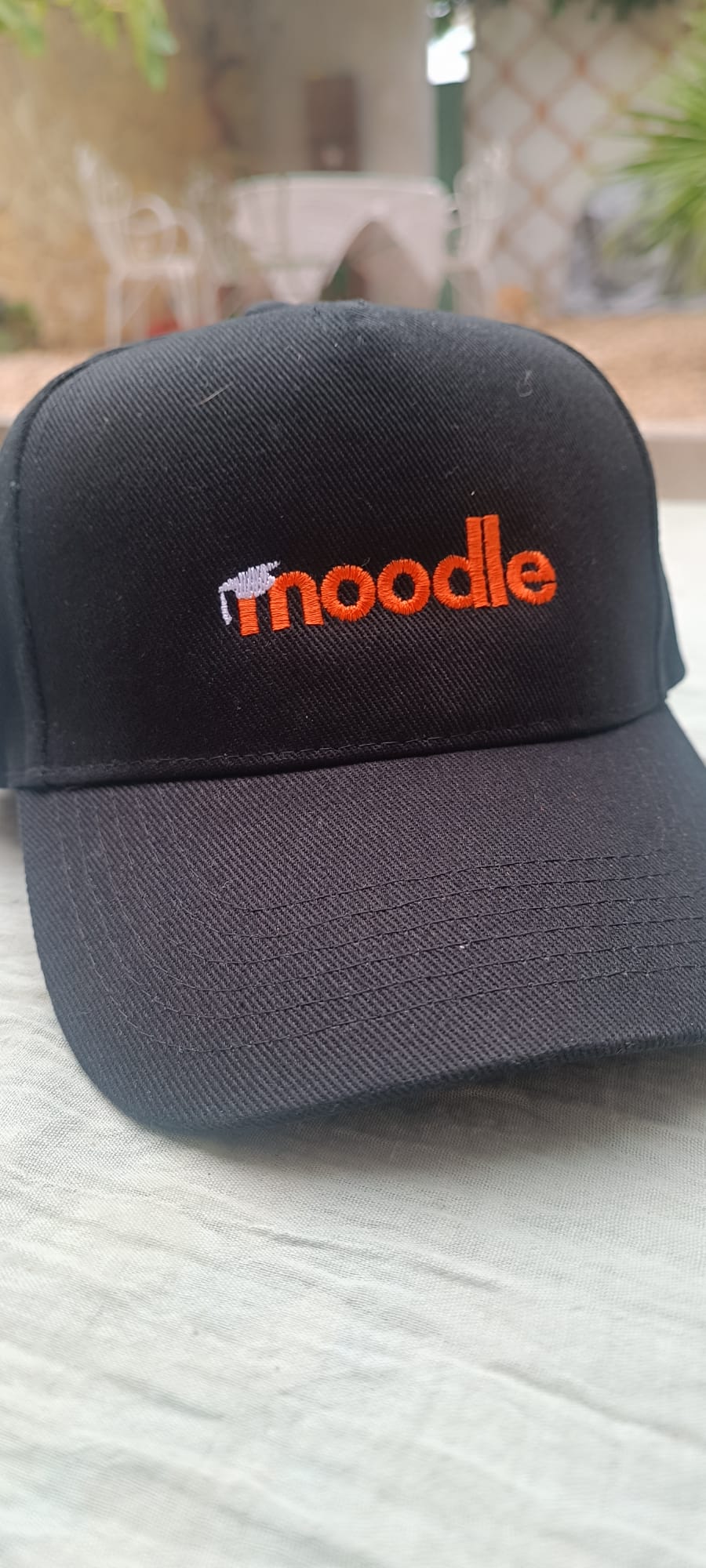 Black cap with Moodle logo in orange
